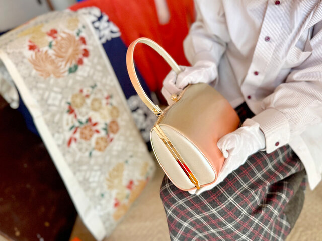 着物姿のお客様のブランドバッグを査定する様子